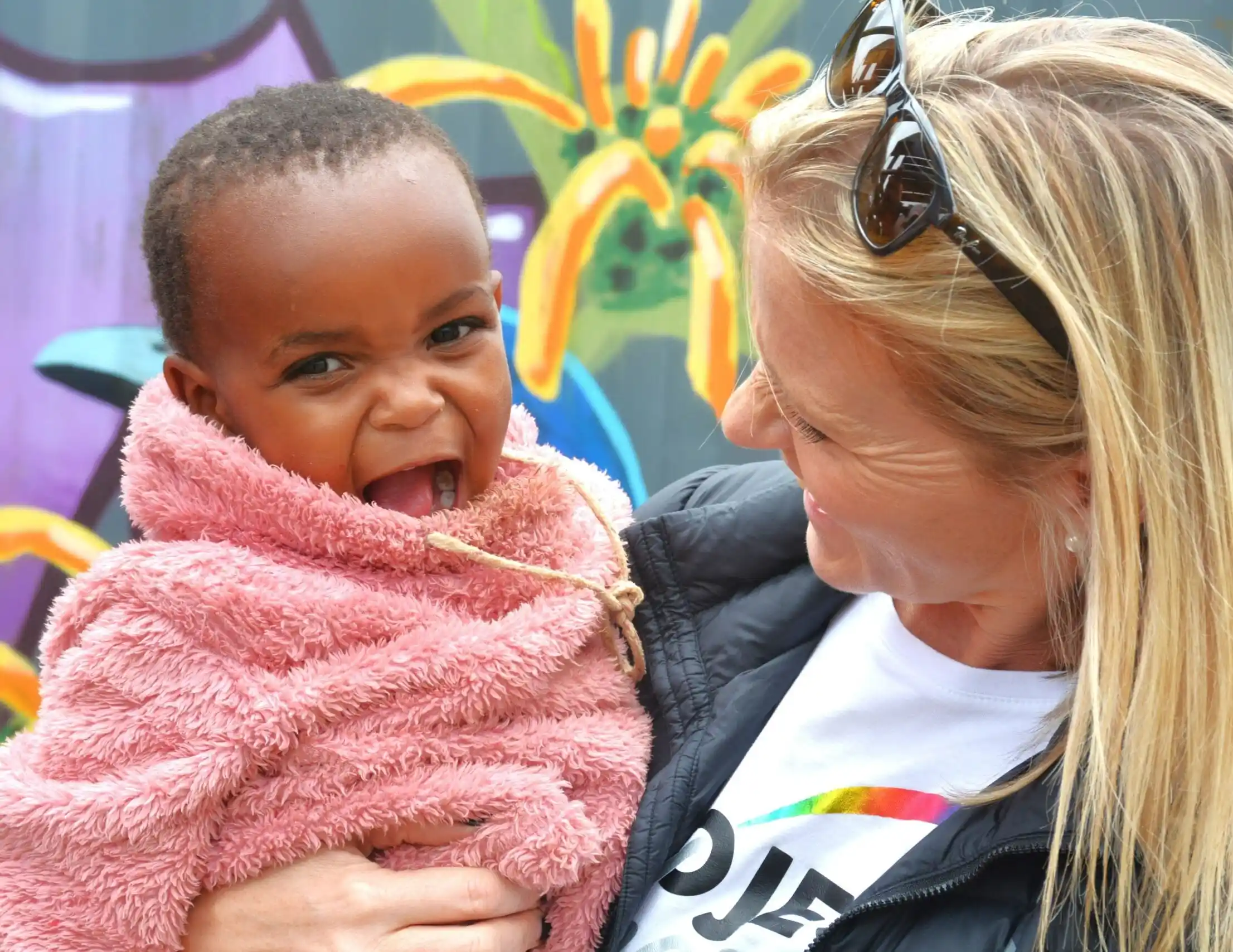 A lady holding a smiling baby girl. Kirsten McGregor-Director Project Hope ECD. KZN