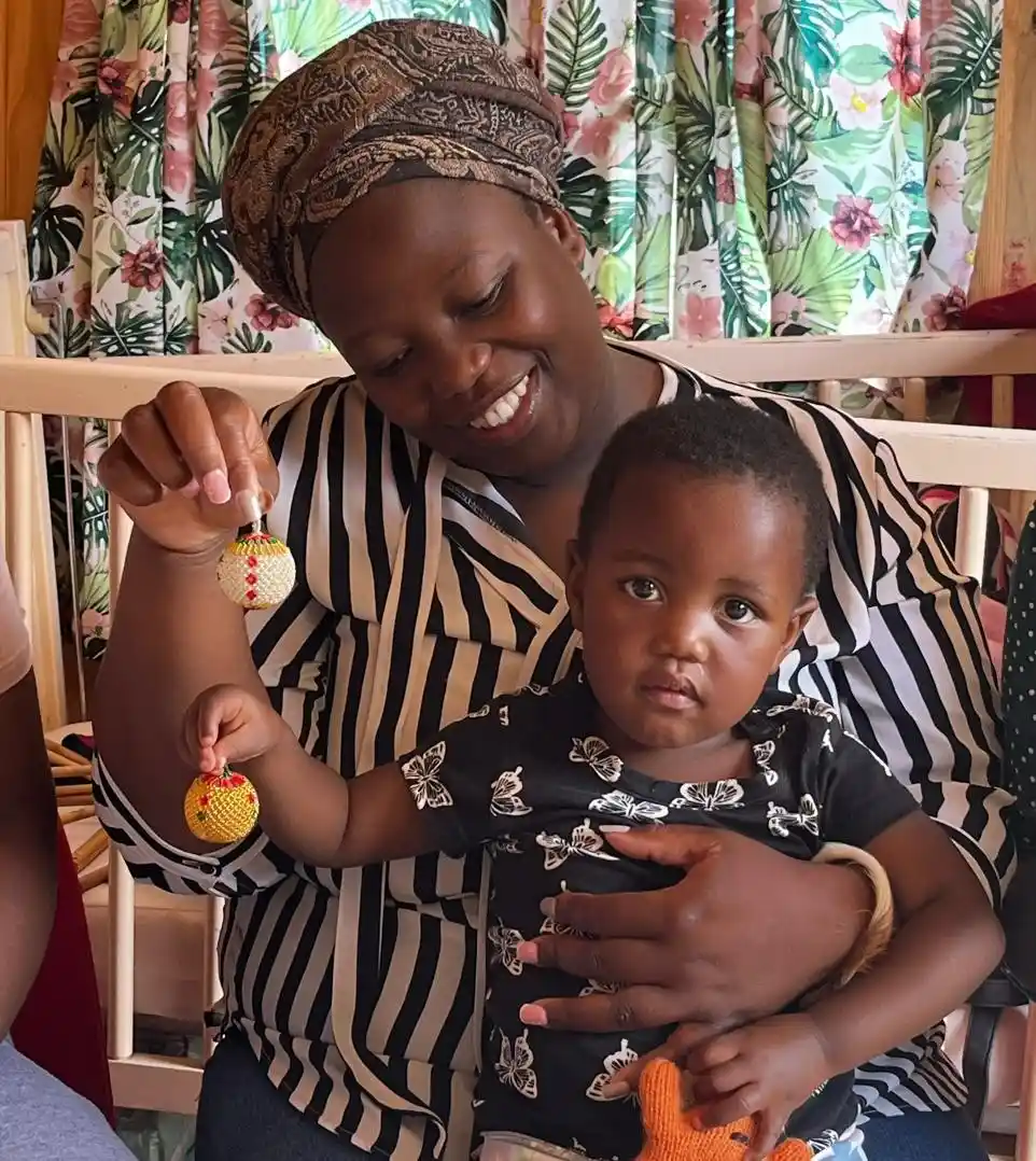 A mother and child holding up beadwork. Sino and Esihle from Project Hope. Women in ECD, KZN, SA.
