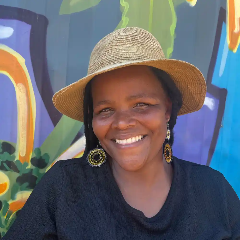 A colourful portrait of Zinhle Phakathi, a creative caregiver artisan and leader at Project Hope’s sustainable social enterprise in KZN.