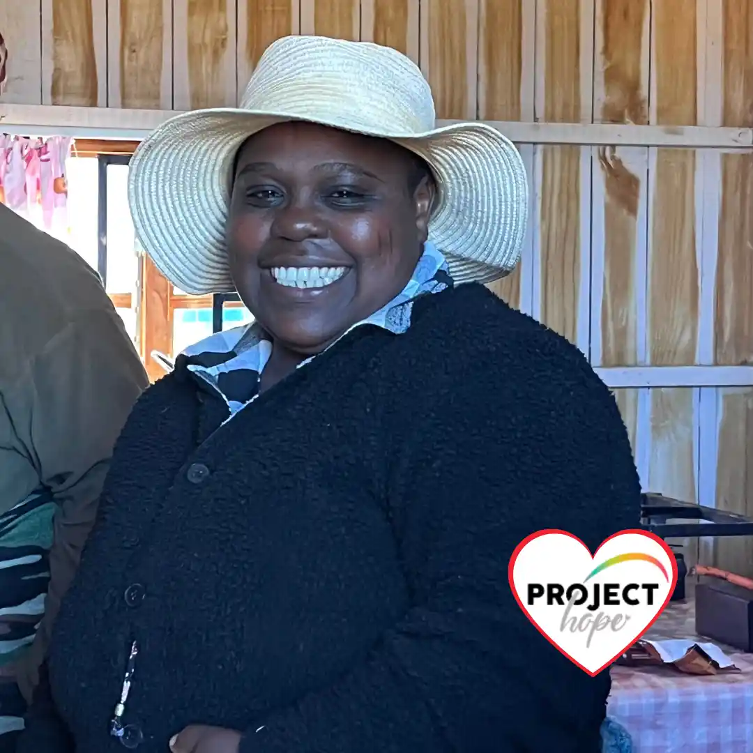 Smiling preschool teacher Zizile Mdunge stands in her KwaNyuswa classroom. Donors can fund local ecd teacher qualifications.