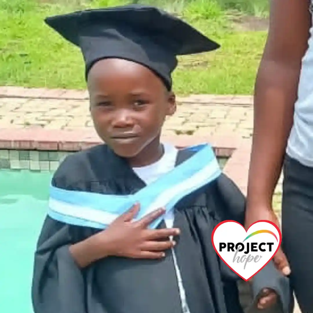 A proud preschool graduate wears a cap and gown, showing the long-term impact when donors choose to sponsor an ecd classroom.
